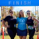 Susie Boyle with two runners, smiling at the finish line.