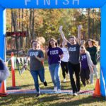 A group of 5k runners going through the finish line.