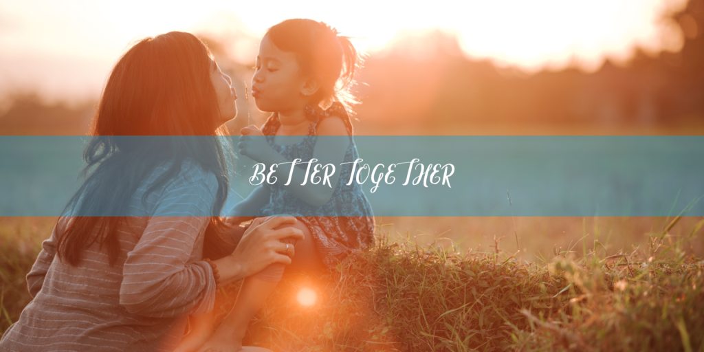 Mom and daughter outside during a sunset with the slogan "better together" on a blue banner.