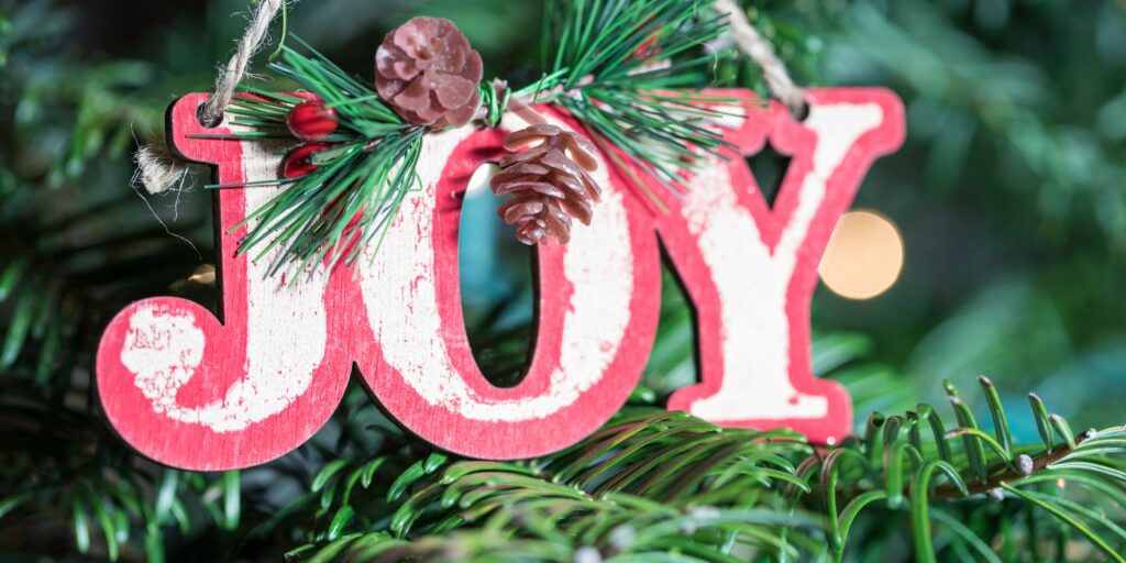 Christmas tree with "Joy" ornament.