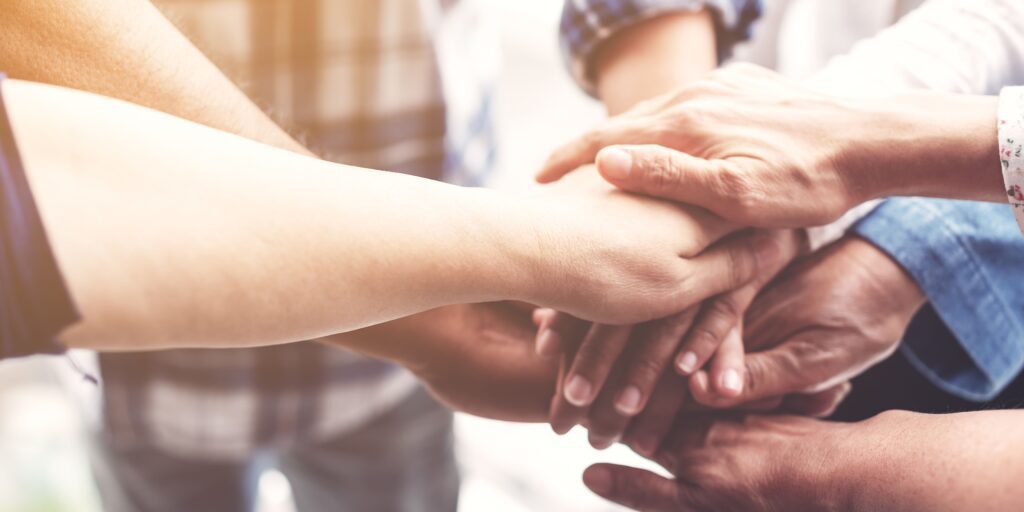 A community group holding hands, signifying teamwork.