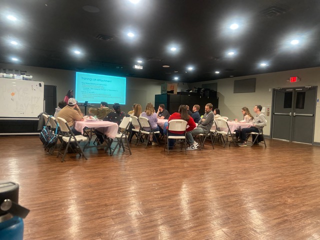 Greenville County Support Group members watching a PowerPoint presentation together at tables with chairs surrounding the tables.