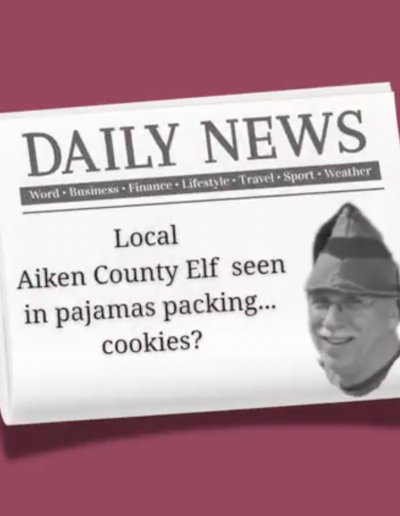 Scott's Story: Scott Bowser in an elf hat on a fake newsletter headline about an Aiken County Elf packing Christmas cookies.